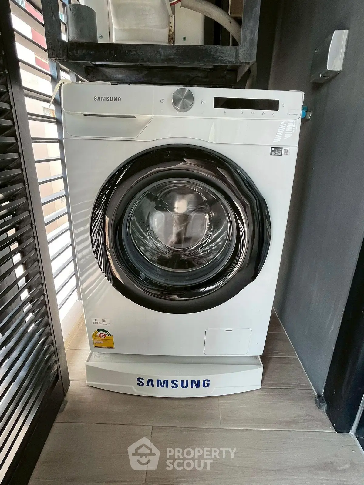 Modern Samsung washing machine in sleek laundry area with wooden flooring