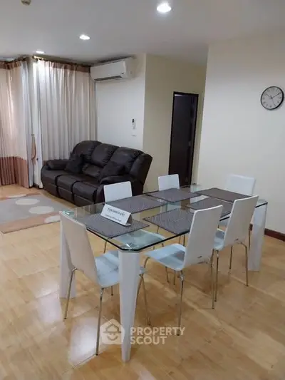 Spacious living room with modern dining area and comfortable seating in a stylish apartment.