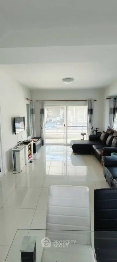 Spacious modern living room with sleek furniture and large windows for natural light.