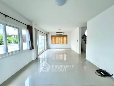 Spacious modern living room with large windows and glossy tile flooring