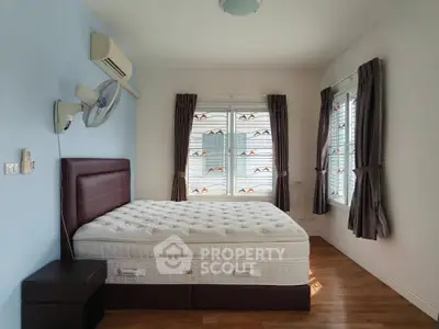 Spacious bedroom with large windows and modern furnishings