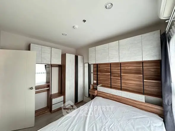 Modern bedroom with stylish wooden furniture and ample storage space.