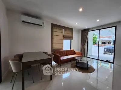 Modern living room with sleek furniture and large windows for natural light.