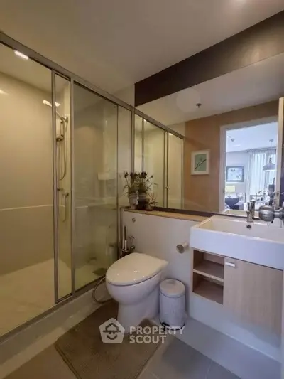 Modern bathroom with glass shower and sleek fixtures in a contemporary apartment.