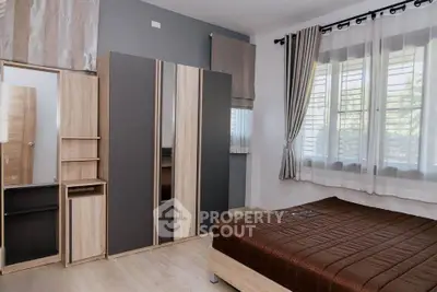 Modern bedroom with stylish wardrobe and large windows for natural light.