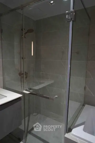 Modern bathroom with glass shower enclosure and sleek fixtures