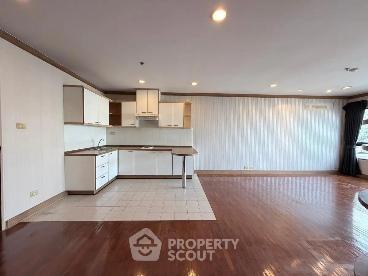 Spacious open-plan living room with modern kitchen and hardwood floors