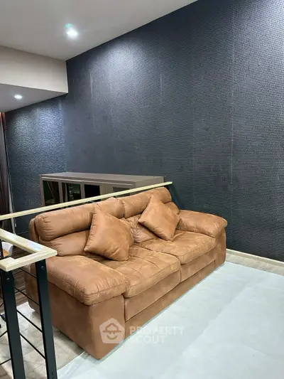 Modern living room with stylish brown leather sofa and textured wall design