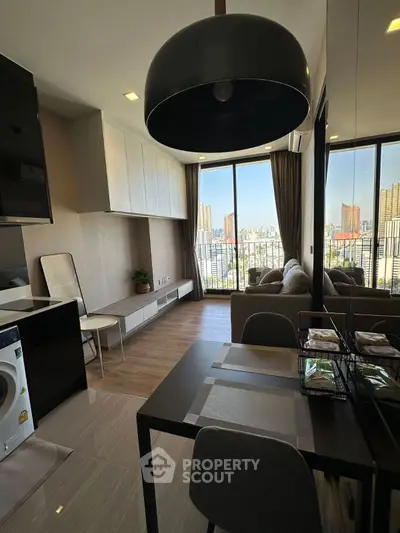 Modern living room with city view, sleek furniture, and washing machine in open layout.