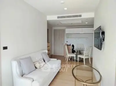 Modern living room with sleek furniture and wall-mounted TV in a cozy apartment.