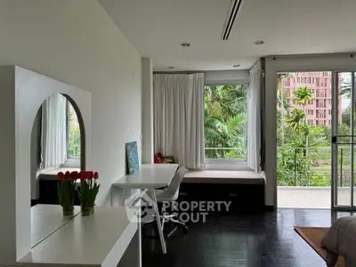 Modern living room with large windows and lush garden view
