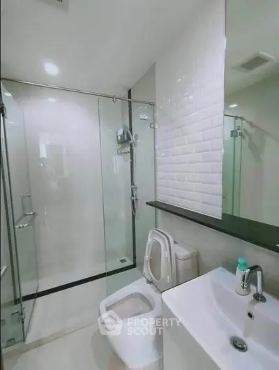 Modern bathroom with glass shower and sleek white fixtures