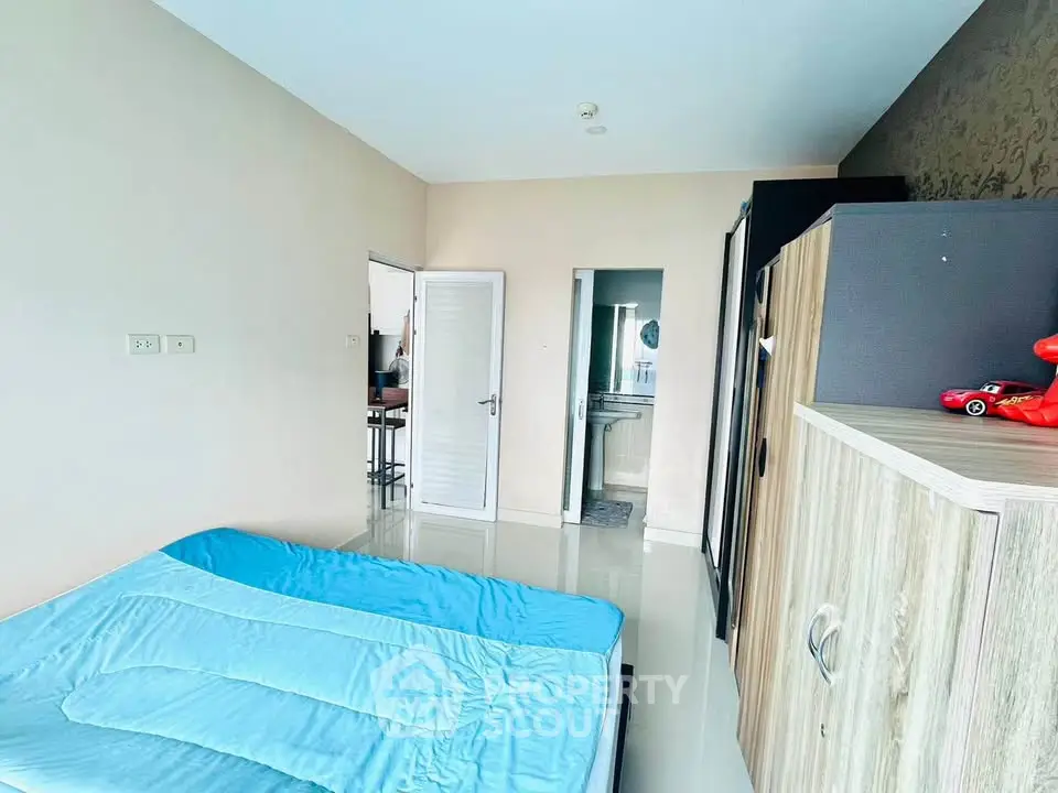 Spacious bedroom with modern decor and natural light, featuring a comfortable bed and stylish wardrobe.