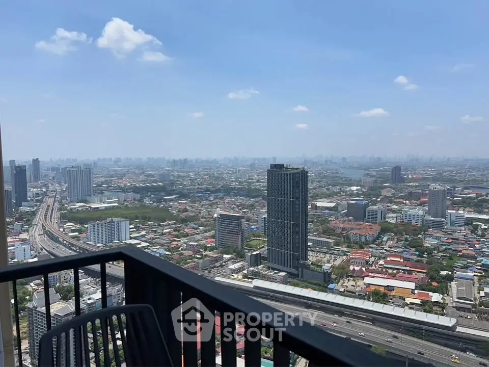 Stunning cityscape view from high-rise balcony overlooking urban skyline and river.