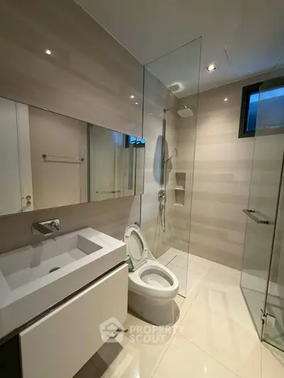 Modern bathroom with glass shower and sleek fixtures in a contemporary home.