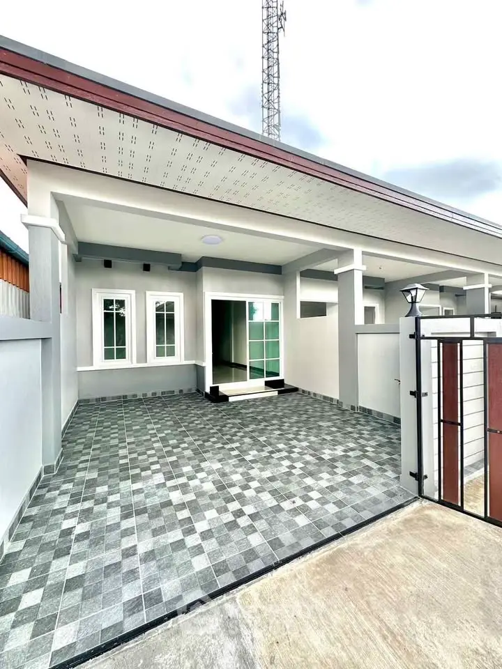 Modern single-story home with spacious tiled driveway and sleek exterior design.