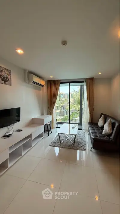 Modern living room with sleek furniture and large window offering a scenic view, perfect for relaxation.