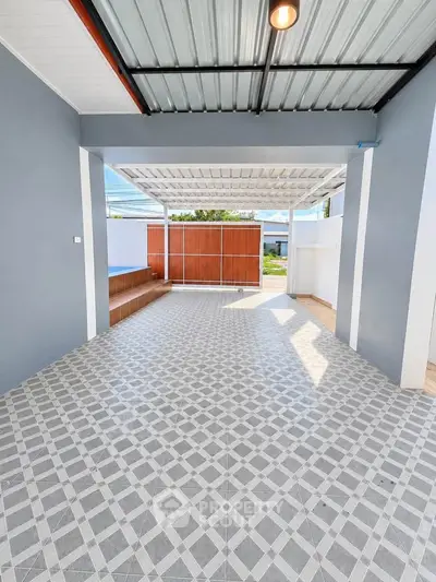Spacious covered patio with modern tiled flooring and open view, perfect for outdoor relaxation.