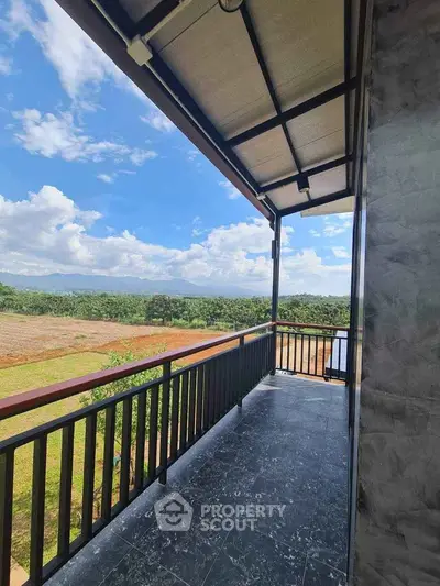 Spacious balcony with stunning countryside view and modern railing design.