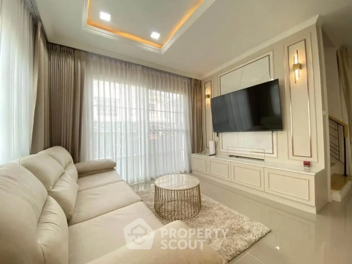Luxurious living room with modern decor, large TV, and plush sofa in elegant home.