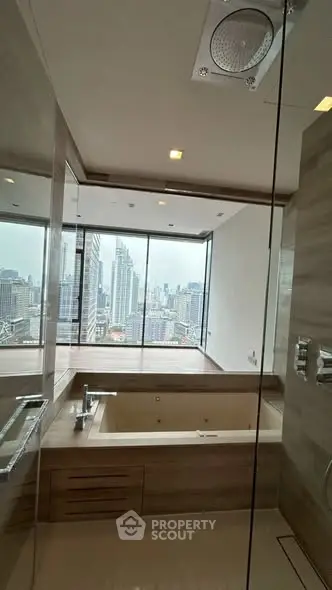Luxurious bathroom with city view and modern bathtub in high-rise apartment.