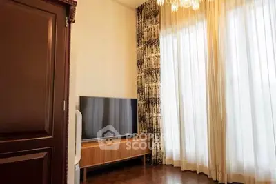 Elegant living room with modern TV and luxurious curtains