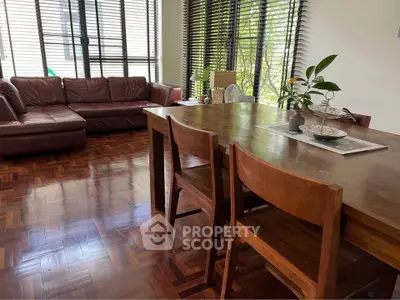 Spacious living room with wooden flooring and elegant furniture, perfect for family gatherings.