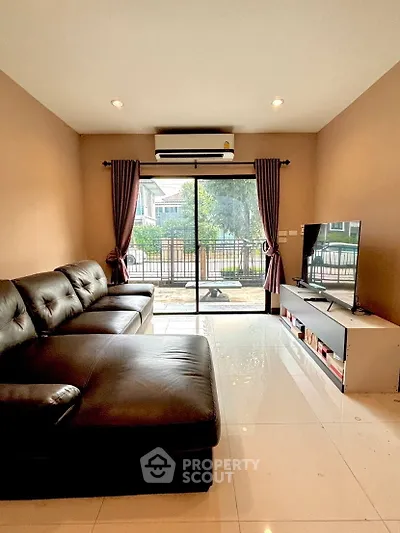 Spacious living room with leather sofa and large window view