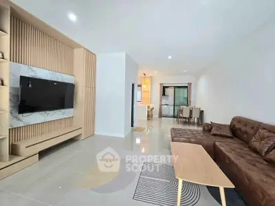 Modern living room with sleek design and open layout leading to dining area.