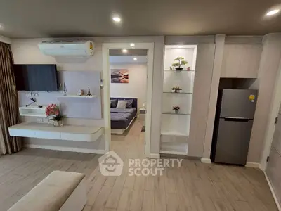 Modern open-plan living room with sleek design and cozy bedroom view