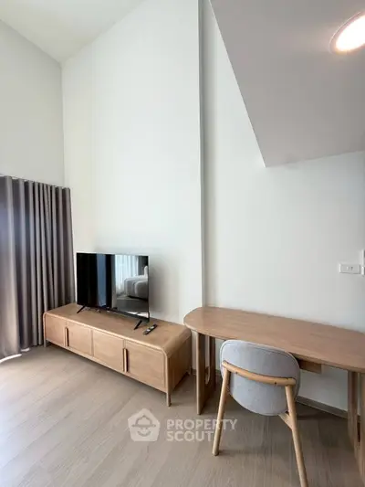 Modern living room with sleek TV stand and stylish desk, perfect for a cozy home office setup.