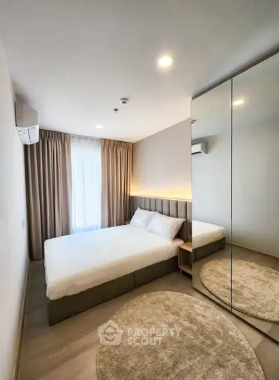 Modern bedroom with mirrored wardrobe and cozy lighting