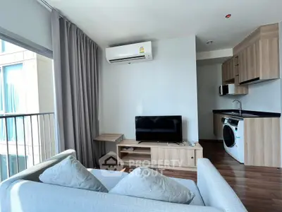 Modern living room with sleek furniture and integrated kitchen appliances in a bright apartment.