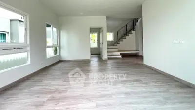 Spacious modern living room with elegant staircase and large windows