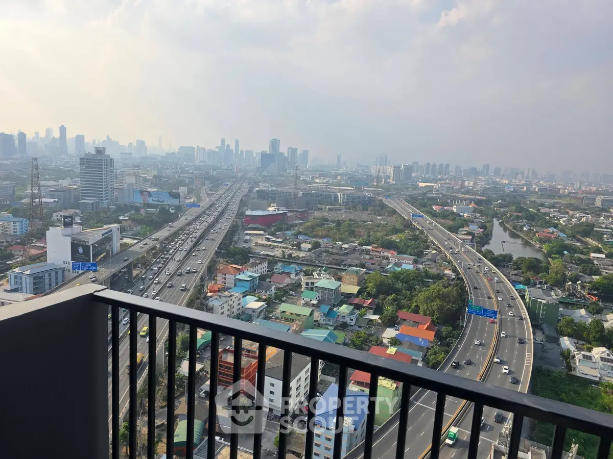 Stunning cityscape view from high-rise balcony overlooking bustling highways and skyline.