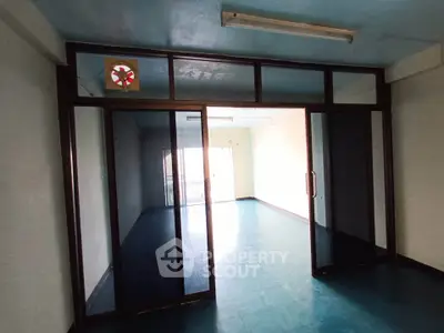 Spacious empty room with sliding glass doors and blue flooring, ideal for customization.
