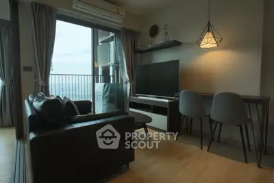 Modern living room with balcony view, stylish furniture, and ambient lighting.