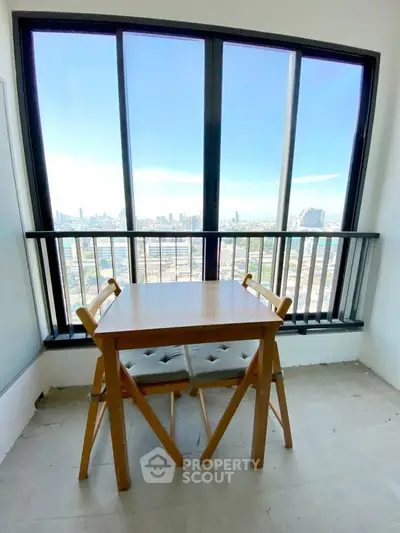 Charming balcony with stunning city view, featuring a cozy wooden table and chairs for relaxation.