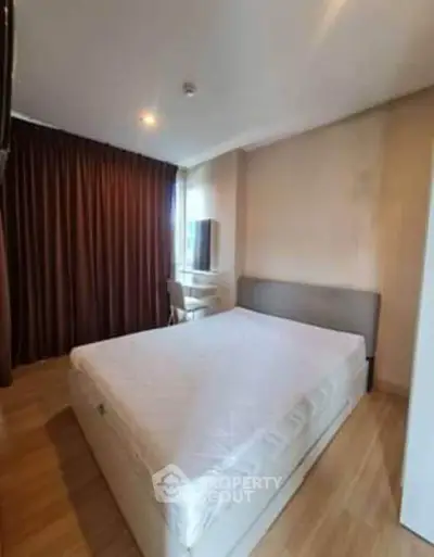 Cozy bedroom with large window and modern furnishings in a stylish apartment.
