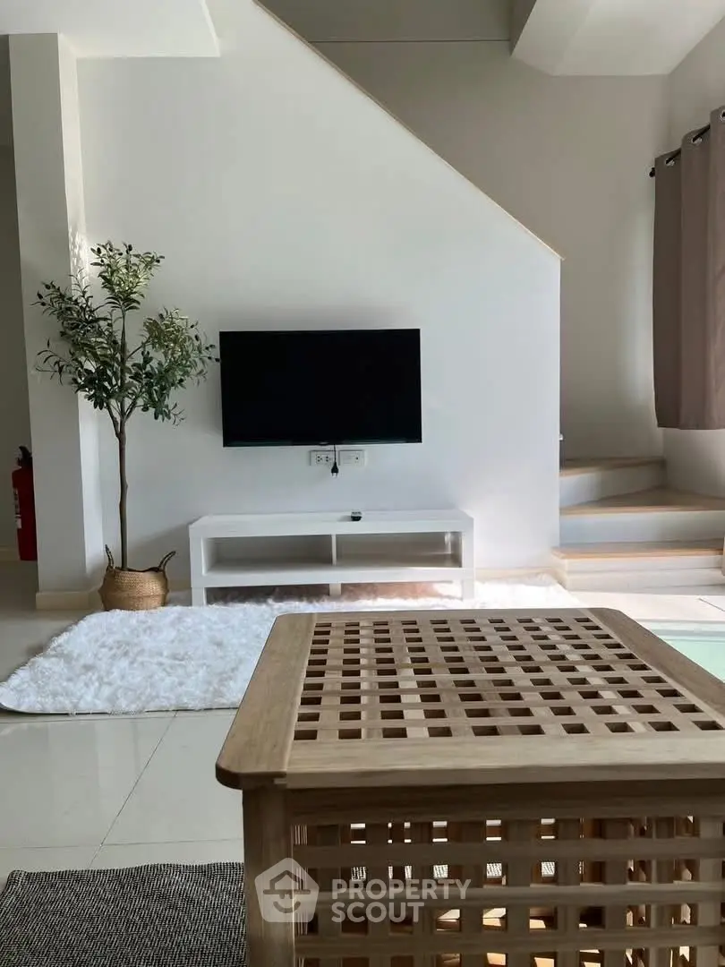 Modern living room with TV, stylish furniture, and cozy decor