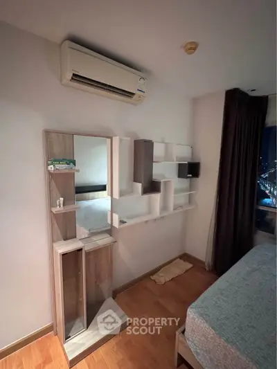 Modern bedroom with stylish shelving and air conditioning, featuring a cozy bed and night city view.