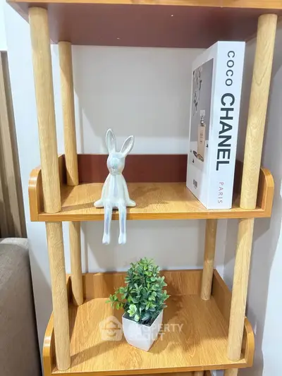 Stylish wooden shelf with decorative items and a book, perfect for modern living room decor.