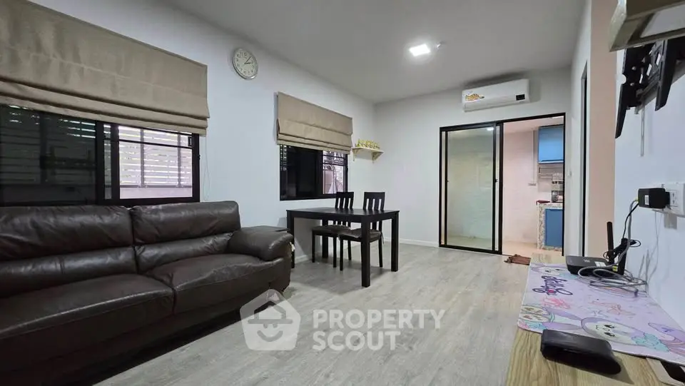 Modern living room with sleek furniture and open layout, featuring a cozy dining area and stylish decor.