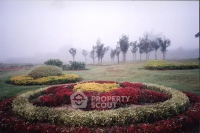 Serene garden landscape with colorful flower beds and misty trees, perfect for tranquil living.
