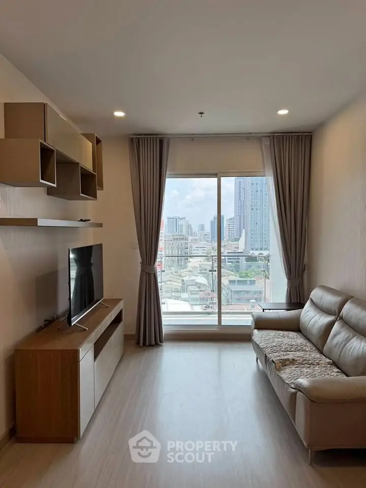 Modern living room with city view, featuring sleek furniture and large window for natural light.