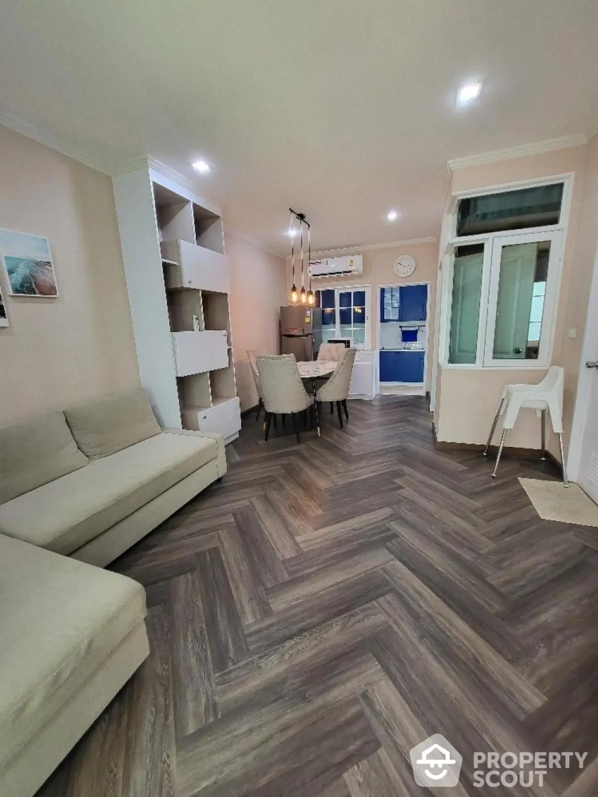 Modern living room with elegant herringbone flooring and cozy dining area