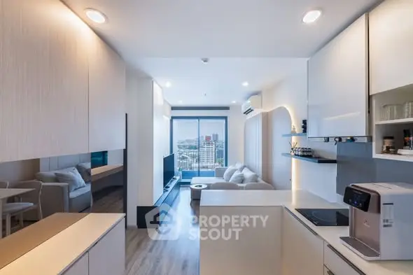 Modern open-layout living room with kitchen, featuring sleek design and city view.