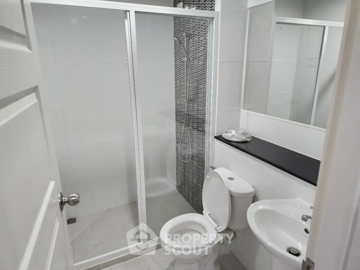 Modern bathroom with glass shower enclosure and sleek fixtures