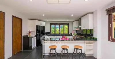 Modern kitchen with sleek black countertops and bar seating in a spacious open layout.