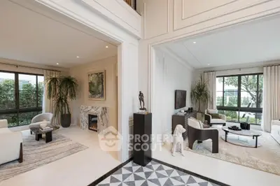 Luxurious dual living rooms with elegant decor and large windows overlooking greenery.